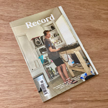 Magazine cover titled 'Record' on a wooden surface